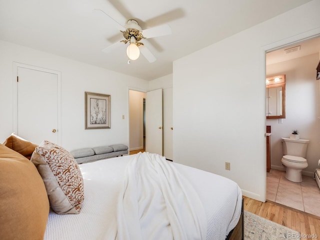 bedroom with light wood-type flooring, visible vents, ensuite bathroom, baseboards, and ceiling fan