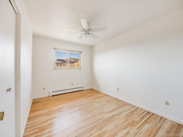 empty room with a baseboard radiator, baseboards, wood finished floors, and a ceiling fan