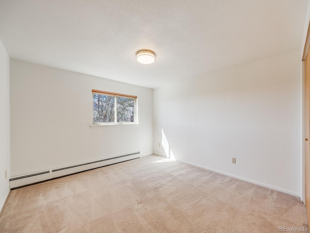 spare room featuring carpet flooring, baseboard heating, and a textured ceiling