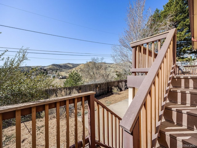 wooden terrace with a mountain view, stairway, and fence