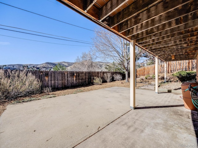 view of patio featuring a mountain view and a fenced backyard