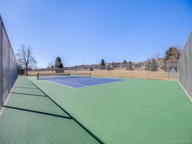 view of tennis court featuring fence