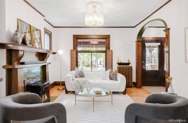 1220 S Vine St, Denver, CO 80210 - living room with radiator, wood finished floors, a chandelier, ornamental molding, and arched walkways