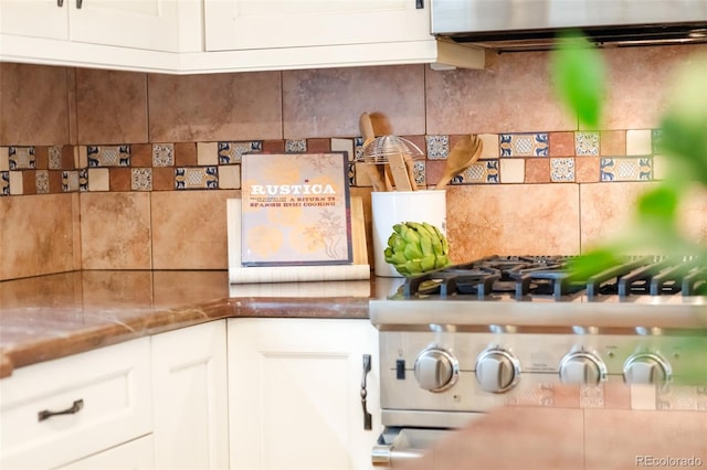 1220 S Vine St, Denver, CO 80210 - kitchen view of backsplash, ventilation hood, white cabinetry, and stovetop