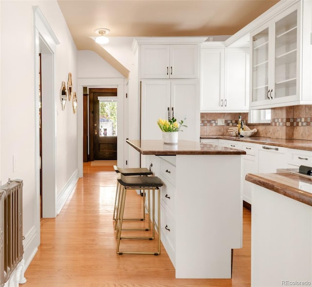 1220 S Vine St, Denver, CO 80210 - kitchen with a kitchen island, light wood finished floors, white cabinetry, and tasteful backsplash