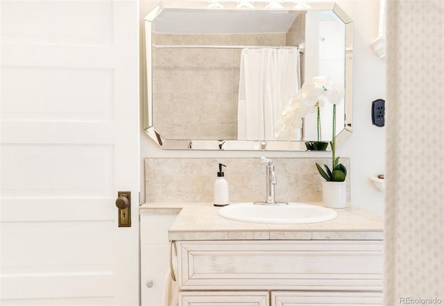 1220 S Vine St, Denver, CO 80210 - bathroom with vanity, curtained shower, wallpapered walls, and decorative backsplash