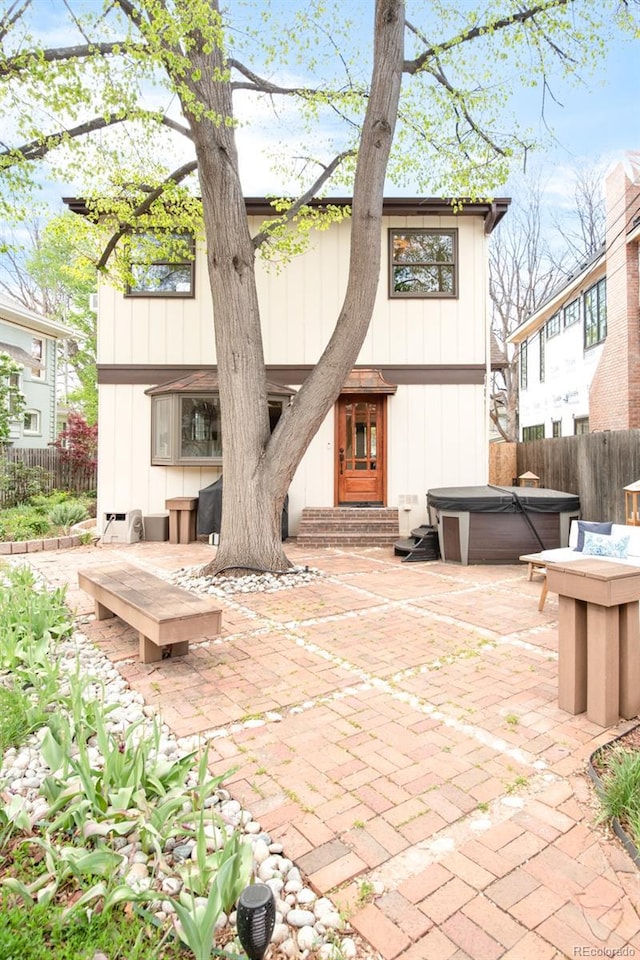 1220 S Vine St, Denver, CO 80210 - rear view of property featuring a hot tub, fence, a patio area, and entry steps