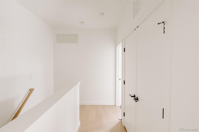 1601 Park Ave Unit 214, Denver, CO 80218 - hallway featuring an upstairs landing, baseboards, and light wood-style flooring