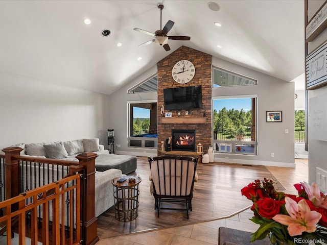 1505 Castlecombe Ln, Monument, CO 80132 - living area with a ceiling fan, healthy amount of natural light, a stone fireplace, wood finished floors, and high vaulted ceiling