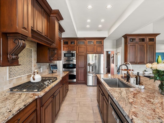 1505 Castlecombe Ln, Monument, CO 80132 - kitchen with appliances with stainless steel finishes, a sink, recessed lighting, tasteful backsplash, and light stone countertops