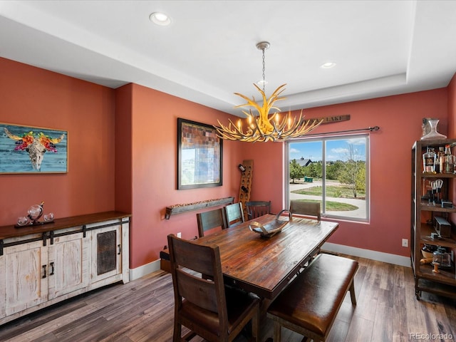 1505 Castlecombe Ln, Monument, CO 80132 - dining area with a chandelier, wood finished floors, recessed lighting, baseboards, and a tray ceiling