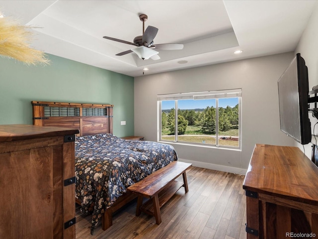 1505 Castlecombe Ln, Monument, CO 80132 - bedroom featuring baseboards, wood finished floors, recessed lighting, a tray ceiling, and ceiling fan