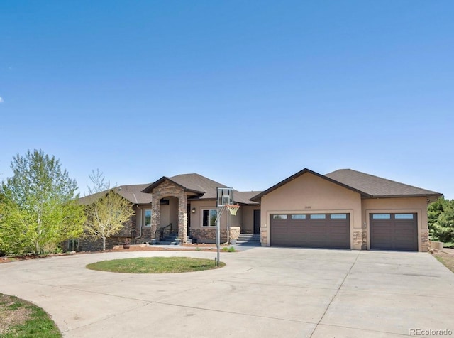 1505 Castlecombe Ln, Monument, CO 80132 - view of front of home featuring stone siding, driveway, a garage, and stucco siding