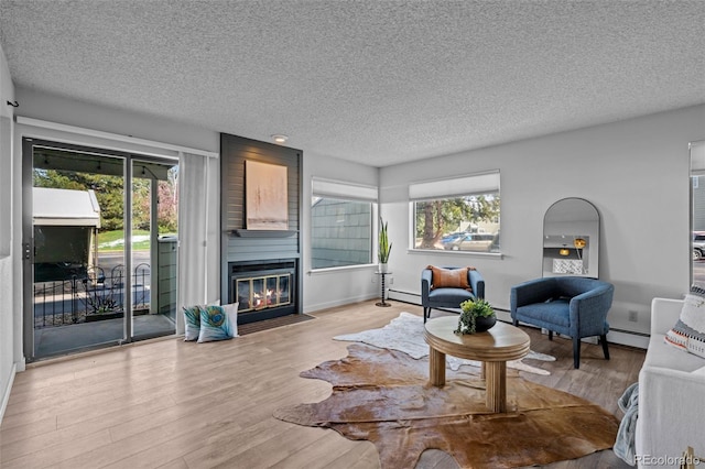 living area featuring a wealth of natural light, a textured ceiling, and wood finished floors