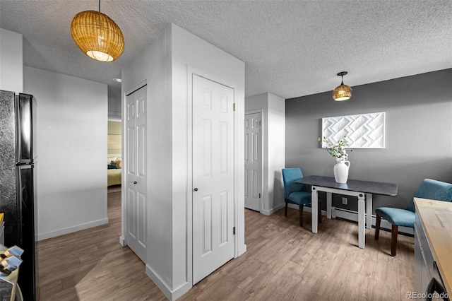 sitting room with a textured ceiling, wood finished floors, and baseboards