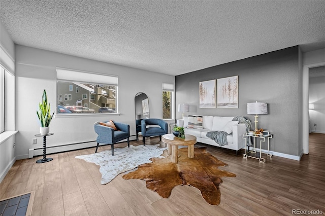 living area featuring arched walkways, baseboards, a textured ceiling, and wood finished floors