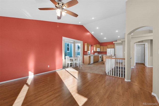 kitchen featuring light hardwood / wood-style floors, white appliances, high vaulted ceiling, and ceiling fan