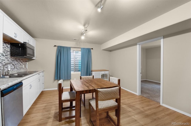 dining area featuring track lighting, light hardwood / wood-style floors, and sink