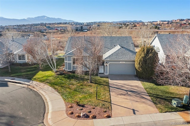 view of front of property featuring a front yard, a garage, and a mountain view