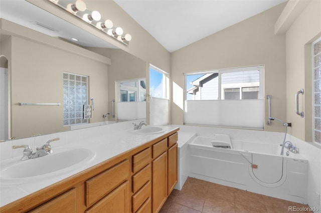 bathroom with a bath, lofted ceiling, tile patterned floors, and vanity