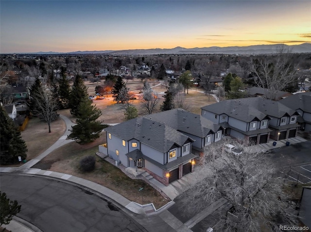 aerial view at dusk featuring a mountain view