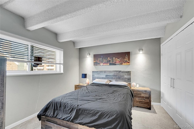 carpeted bedroom with baseboards, a closet, and a textured ceiling