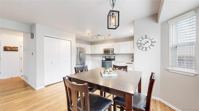 12201 N Holly Way, Brighton, CO 80602 - dining area featuring baseboards and light wood-style floors