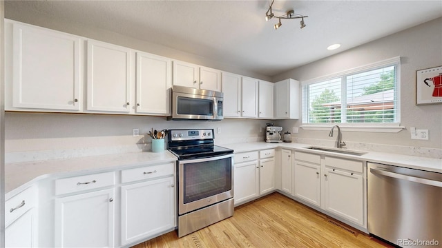 12201 N Holly Way, Brighton, CO 80602 - kitchen with appliances with stainless steel finishes, a sink, white cabinets, and recessed lighting