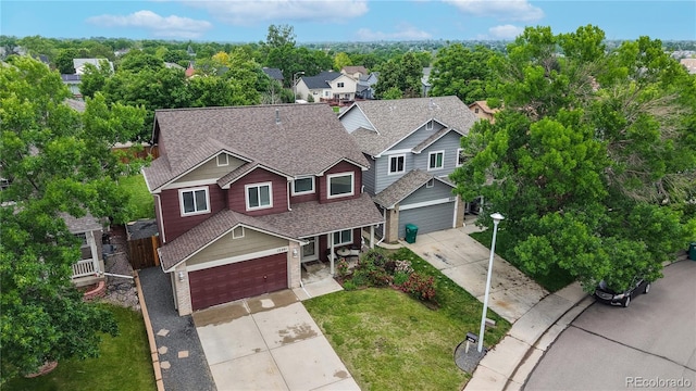 12201 N Holly Way, Brighton, CO 80602 - view of front facade featuring driveway, a shingled roof, a garage, and brick siding