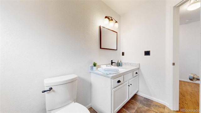 12201 N Holly Way, Brighton, CO 80602 - bathroom featuring vanity, toilet, and baseboards