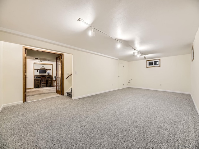 basement with carpet and rail lighting