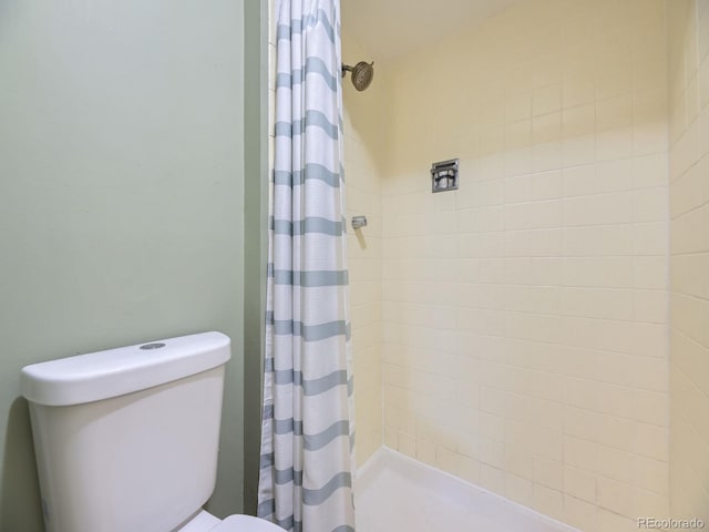 bathroom with curtained shower and toilet