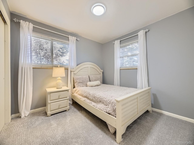 bedroom with multiple windows and light colored carpet