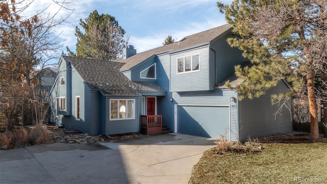 traditional home with roof with shingles, driveway, a chimney, and an attached garage