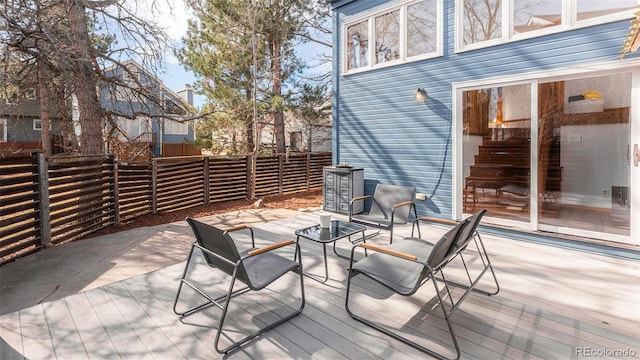 view of patio featuring fence and a deck