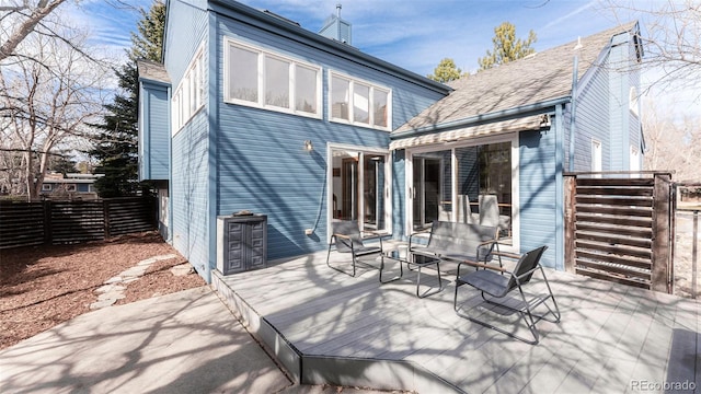 rear view of property featuring fence and a deck