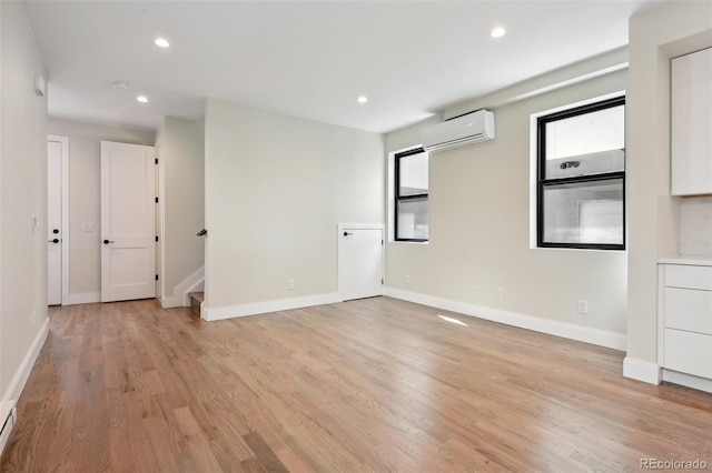1563 N Hooker St, Denver, CO 80204 - spare room featuring a wall mounted air conditioner, light wood-style flooring, recessed lighting, stairs, and baseboards