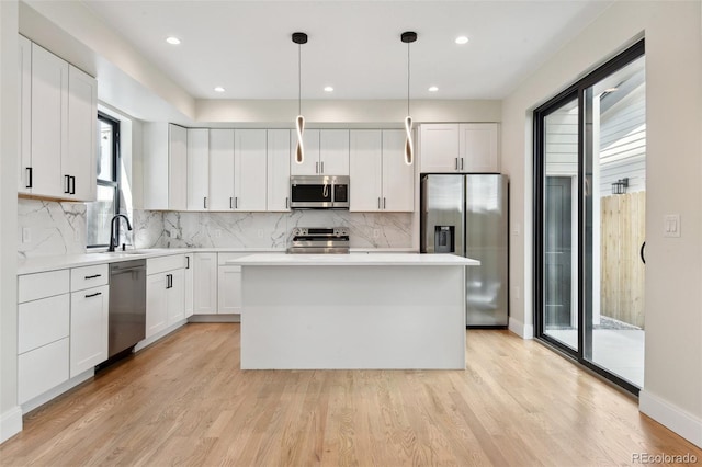 1563 N Hooker St, Denver, CO 80204 - kitchen featuring stainless steel appliances, healthy amount of natural light, a sink, a kitchen island, and recessed lighting