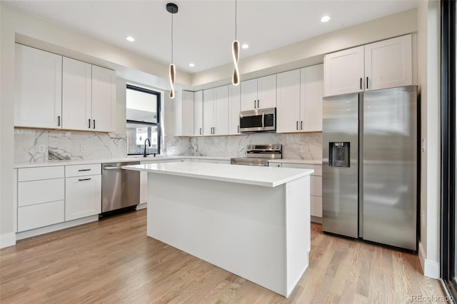 1563 N Hooker St, Denver, CO 80204 - kitchen with stainless steel appliances, a sink, white cabinets, light countertops, and decorative backsplash