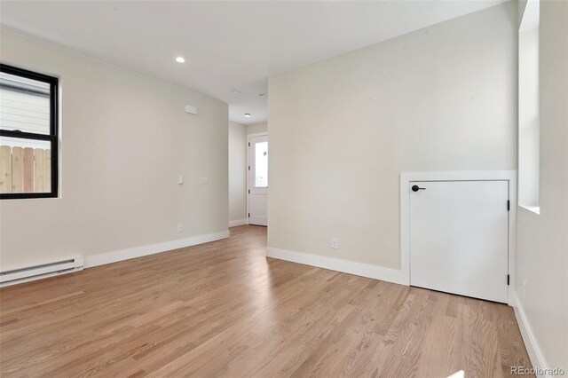 1563 N Hooker St, Denver, CO 80204 - unfurnished room featuring light wood-style flooring, baseboards, recessed lighting, and a baseboard heating unit