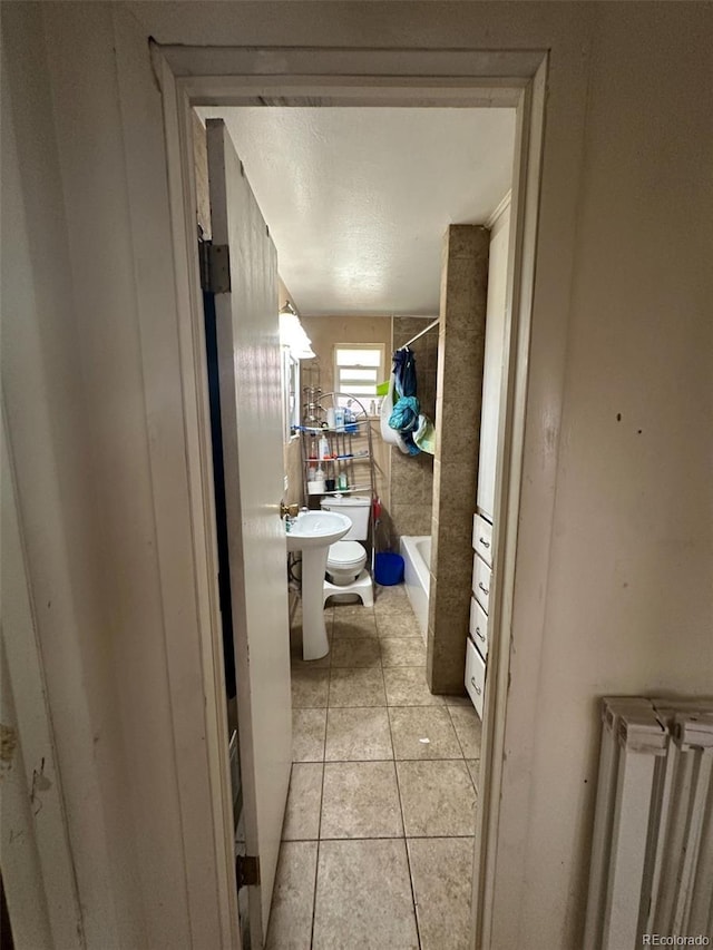 1255 Yates St, Denver, CO 80204 - bathroom with radiator heating unit, tile patterned flooring, and shower / bath combo