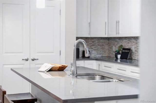 kitchen with white cabinetry, sink, and decorative backsplash