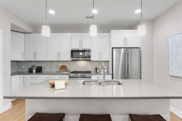 kitchen featuring white cabinetry, a kitchen breakfast bar, sink, and premium appliances