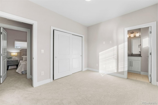 carpeted bedroom featuring ensuite bath and a closet