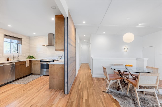 3035 E Maplewood Ave, Centennial, CO 80121 - kitchen with light wood-type flooring, light countertops, wall chimney exhaust hood, and appliances with stainless steel finishes