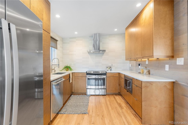 3035 E Maplewood Ave, Centennial, CO 80121 - kitchen with backsplash, appliances with stainless steel finishes, light countertops, light wood finished floors, and wall chimney exhaust hood