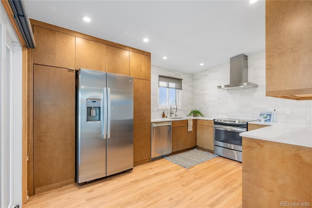3035 E Maplewood Ave, Centennial, CO 80121 - kitchen with light countertops, wall chimney exhaust hood, light wood finished floors, and stainless steel appliances