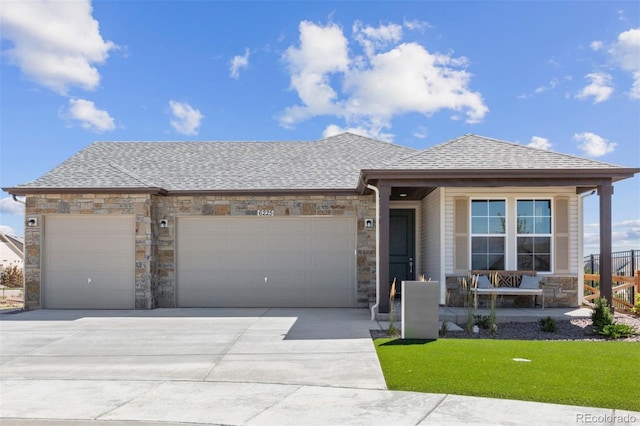22374 E 49th Pl, Aurora, CO 80019 - view of front of property with an attached garage, stone siding, and concrete driveway
