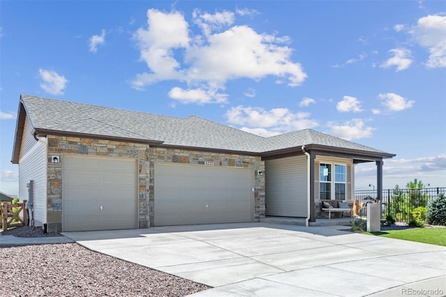 22374 E 49th Pl, Aurora, CO 80019 - view of front of home with stone siding, an attached garage, driveway, and a shingled roof