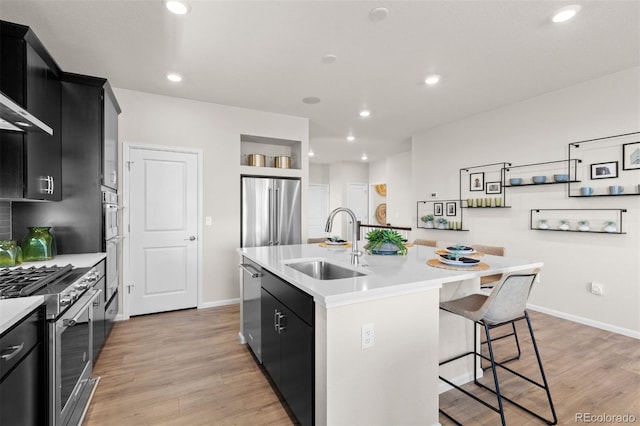 22374 E 49th Pl, Aurora, CO 80019 - kitchen with appliances with stainless steel finishes, dark cabinets, an island with sink, light countertops, and recessed lighting